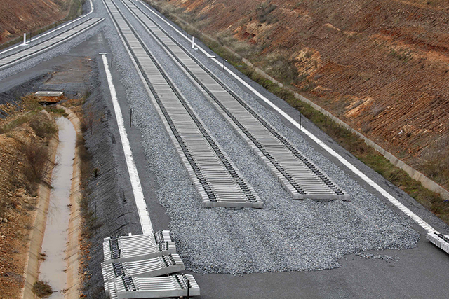 Blick auf eine unvollendete Gleisanlage mit Schotter und Betonplatten.